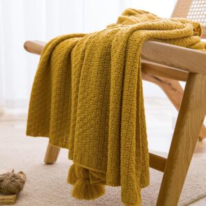 Mustard yellow knitted acrylic throw blanket with tassels