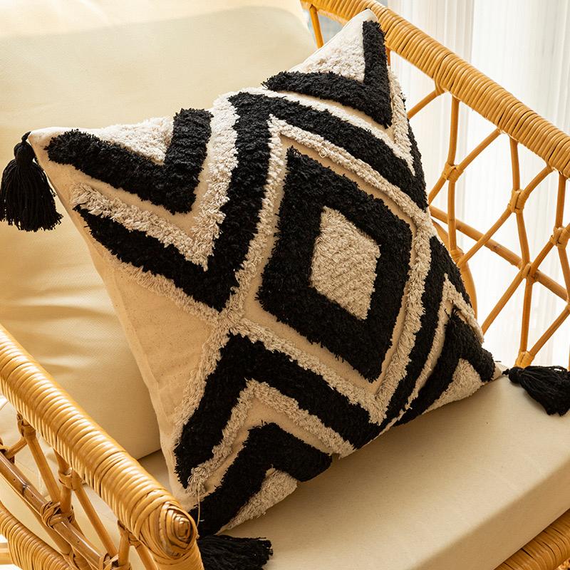 Black and white tufted geometric pillow cover with tassels.